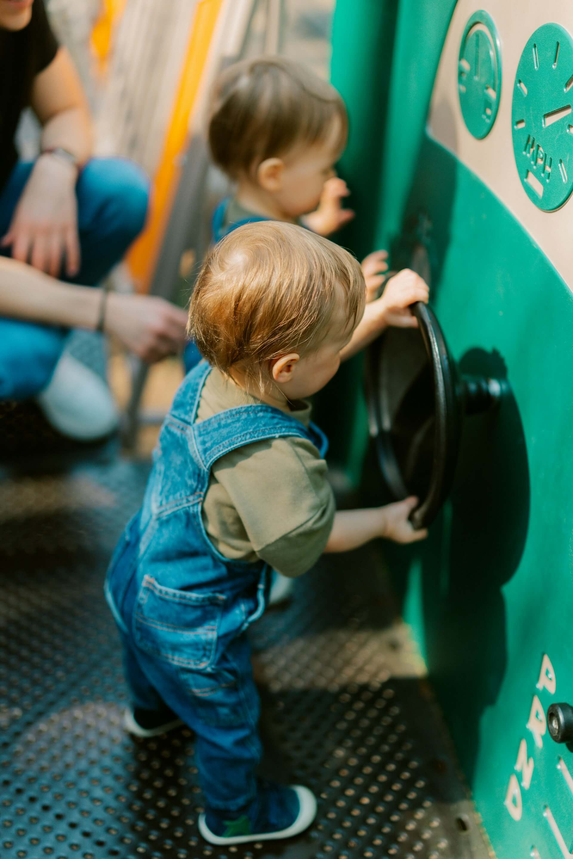 Toddlers exploring a wall of sensory activities