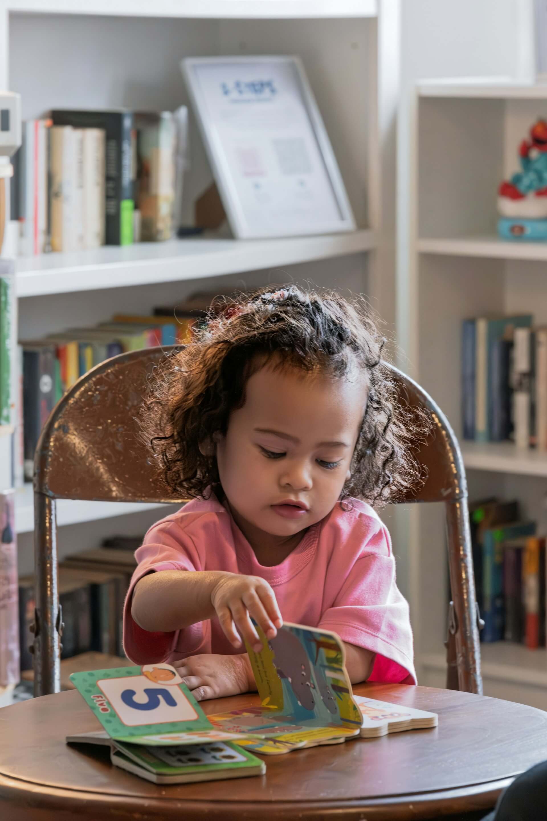 Child looking through a book in the reading area